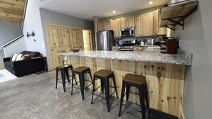 Een moderne keuken met houten kastjes, roestvrijstalen apparatuur en een granieten aanrecht.