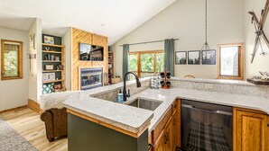 A kitchen with a large island, wooden cabinets, and a built-in dishwasher. - Northern Michigan paradise!  sleeps 7 KING bed. Private association outdoor pool (Mancelona)