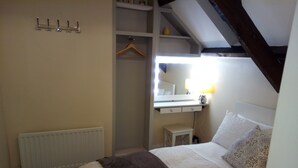 A bedroom with a bed, bedside table, and a small desk with a lamp. - Gorgeous cottage in rural idyl, sleeps 4 (Newcastle-upon-Tyne)