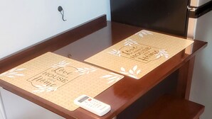 Un tavolo da pranzo in legno con due panche abbinate, un sottopiatti con testo e un piccolo dispositivo elettronico sopra.