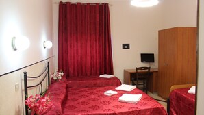 Una habitación de hotel con dos camas, un escritorio, una silla, un armario y un televisor.