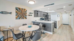 A modern kitchen with grey cabinets, a white countertop, and a built-in oven.