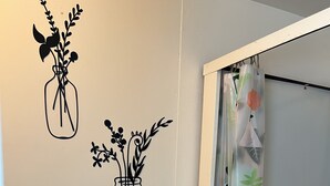 A bathroom with a towel rack, a towel, and decorative wall stickers of vases with flowers.