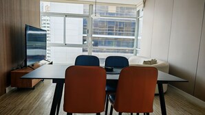 A modern room with a dining table, chairs, a sofa, and a TV. - Lovely Modern Apartment Two Bedrooms, Two Bathrooms, Nice Location (Panamá)
