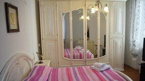 Une chambre à coucher avec un lit, une armoire et un miroir.