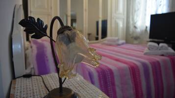 A room with a bed, a decorative glass object on a table, and a television in the corner.