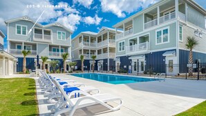 A multi-story residential building with a swimming pool, lounge chairs, and a well-maintained lawn. - A FEW STEPS TO OCEAN in EMERALD ISLE, NC! Come visit walk to all entertainment! (Emerald Isle)
