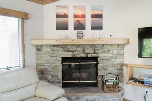 TV connectée, cheminée, livres, chaîne hi-fi