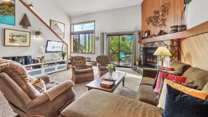 Un salon chaleureux avec une cheminée, des fauteuils confortables et un téléviseur.