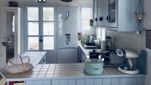 A kitchen with a white tiled backsplash, a cake mixer, and a hanging light fixture. - Tinos Agios Sostis Villa Filippos  five (5) min  walk to the beach - Pet Allowed (Agios Sostis Tinos)