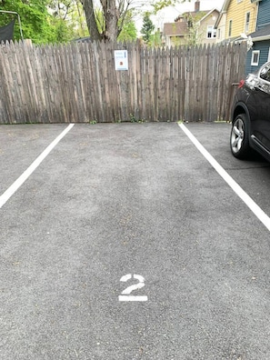 Un área de estacionamiento con una cerca de madera y un letrero.