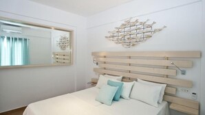 Un dormitorio con cabecera de madera, un espejo grande y un adorno en la pared.
