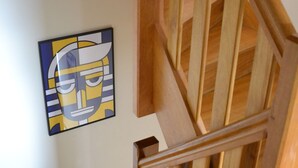 A wooden staircase with a handrail and a wall-mounted artwork. - Cosy house with fireplace (Lannion)