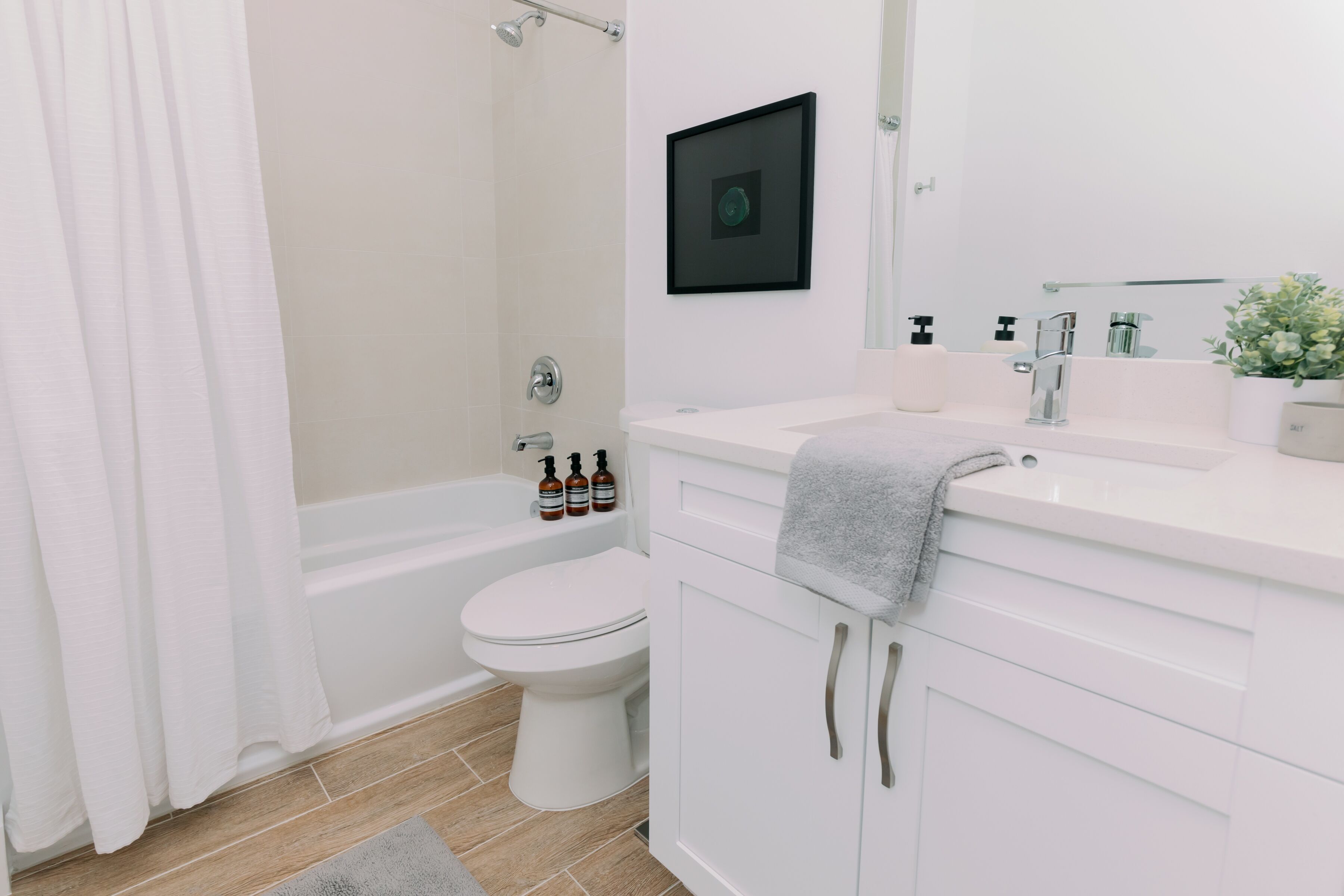 Un baño moderno con bañera, inodoro y muebles blancos.