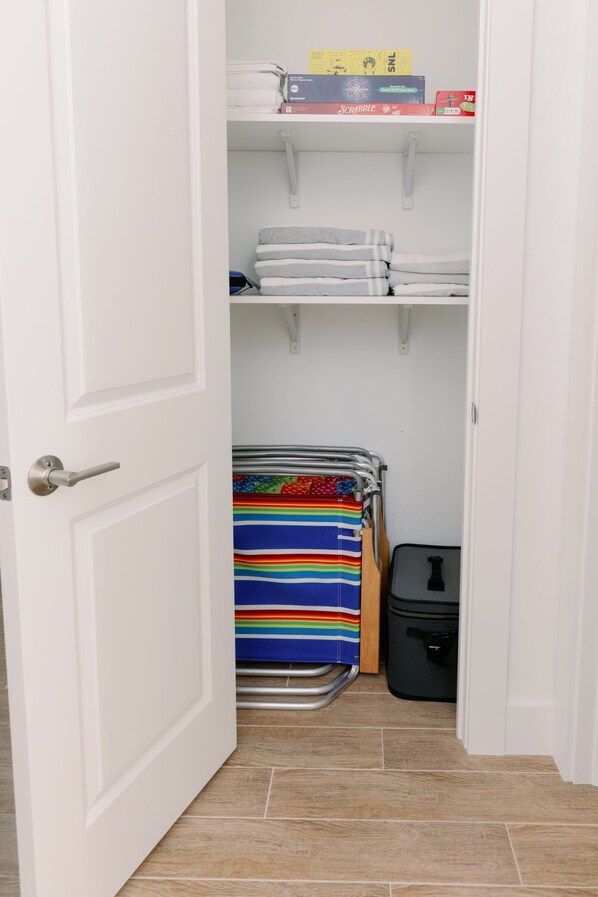 A closet with shelves containing folded towels and a striped blanket.