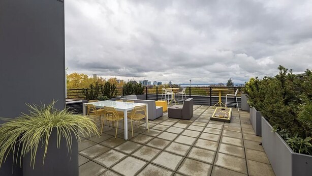 A rooftop patio with a table and chairs, a small table, and a weighing scale. - Space Needle and Mountain View. Top-Floor Condo (Seattle)