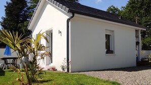 A single-story house with a white exterior, a black roof, and a gravel driveway. - Lovely, cosy little chalet close to a wood (Montardon)