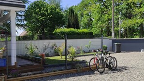 A residential area with a house, a fenced garden, and bicycles parked outside. - Lovely, cosy little chalet close to a wood (Montardon)