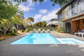 Relax by the rectangular pool surrounded by lounge chairs and enjoy the view from the two-story building's balcony.