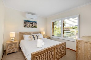 Cozy retreat with a large bed, bedside tables, and a window with a scenic view.
