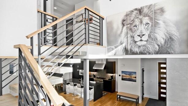Un interior moderno con una escalera, una cocina y un comedor.