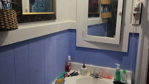 Ein Badezimmer mit einem weißen Waschbecken, blauen Wänden und einem Spiegel darüber.