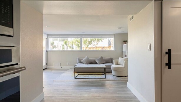A modern living room with a sofa, a coffee table, and a bookshelf. - Basement at 126 · Modern 1bedroom basement apartment newly remodeled (Kirkland)