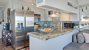 A modern kitchen with stainless steel appliances, a tiled backsplash, and a marble countertop. - *NEW*Fantastic Location! Large Balcony Overlooking Yacht Club. Walk to Hotel Del (Coronado)