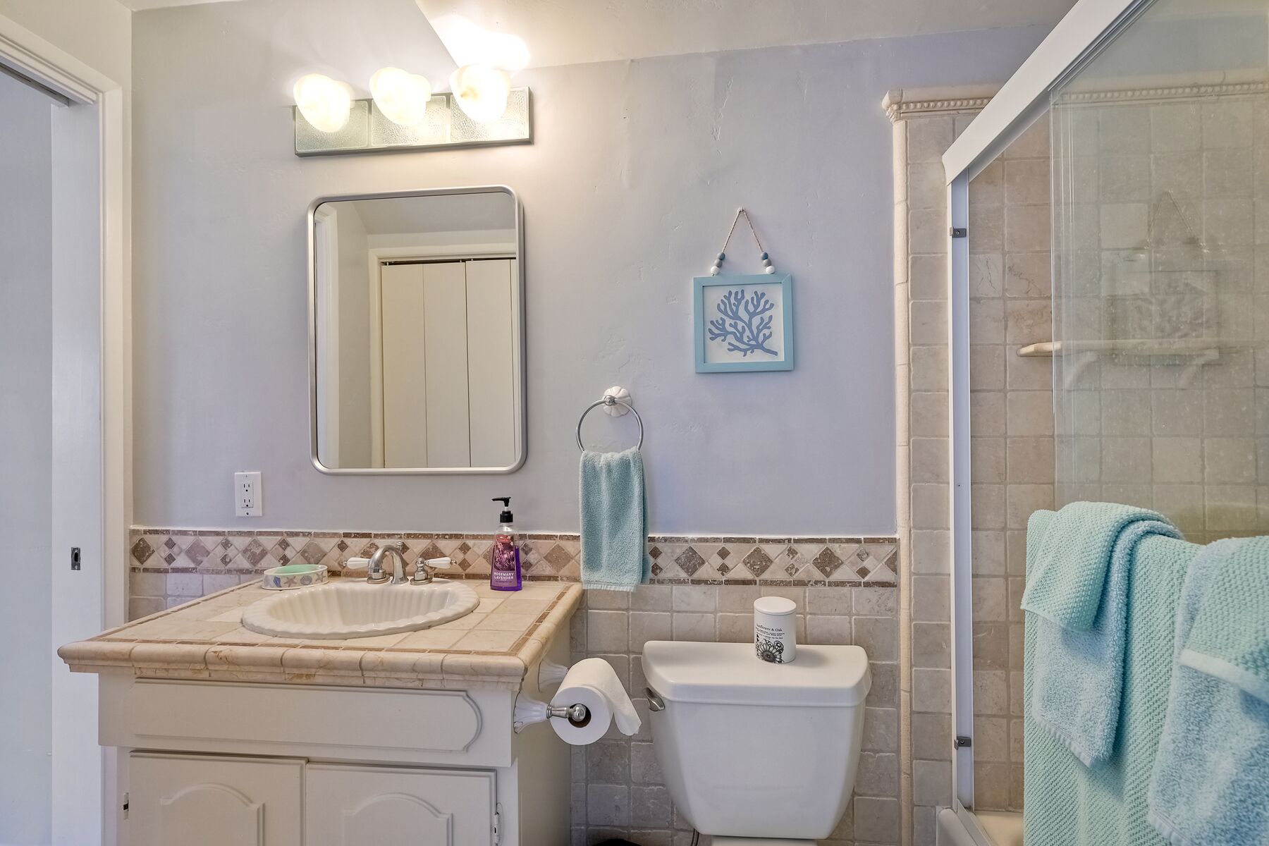 A bathroom with a sink, toilet, and shower.