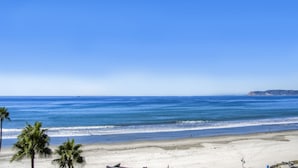 A beach with clear skies, calm sea, and palm trees. - *NEW*Fantastic Location! Large Balcony Overlooking Yacht Club. Walk to Hotel Del (Coronado)