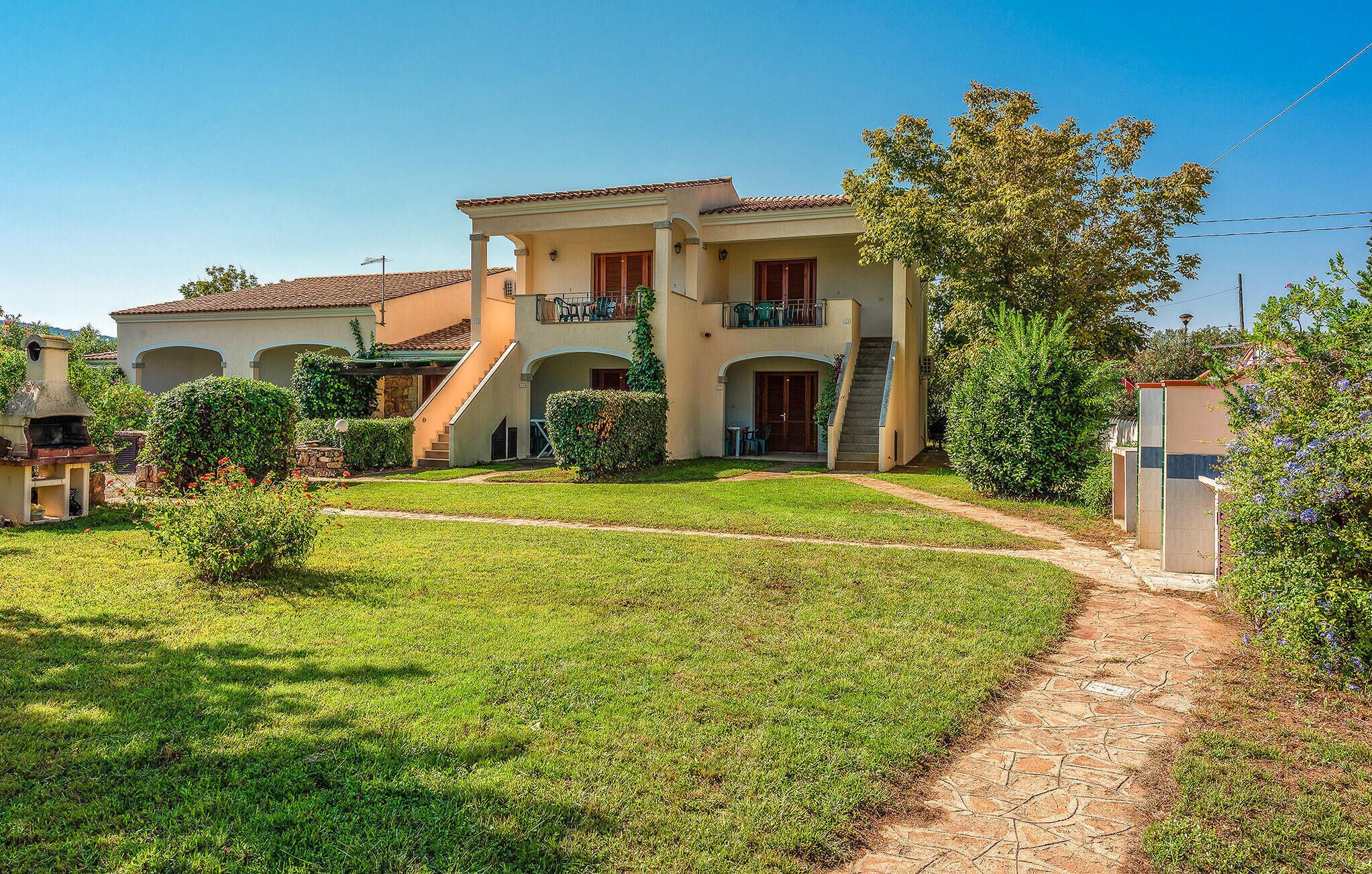 A two-story house with a covered patio and a well-maintained lawn.