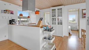A modern kitchen with a central island, white cabinetry, and a view to the outside. - 3 bedroom awesome home in Egernsund (Egernsund)
