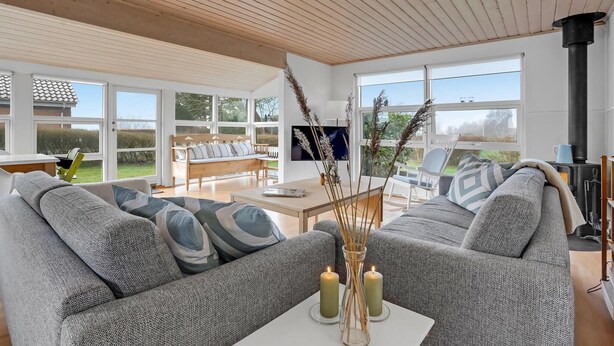 A modern living room with a large sofa, a coffee table, and a fireplace. - 3 bedroom awesome home in Egernsund (Egernsund)