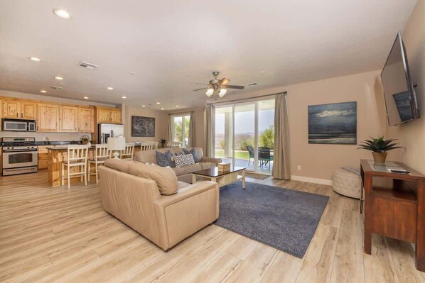 A spacious living area with a sofa, coffee table, and a view of the outdoors.