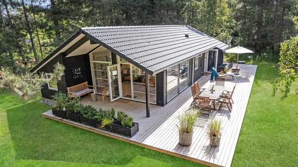 Een modern huis met een ruim terras, een eethoek en een gezellige zithoek.