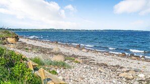 A rocky shoreline with a wooden walkway leading to the water. - Nice home in Kalundborg with WiFi (Kalundborg)