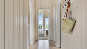 A hallway with wooden walls and a view of the beach through an open door. - Nice home in Kalundborg with WiFi (Kalundborg)