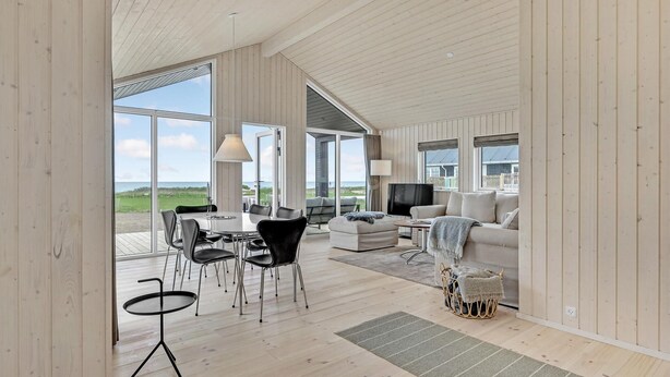 A spacious living area with a large dining table, multiple chairs, a sofa, and a television. - Nice home in Kalundborg with WiFi (Kalundborg)