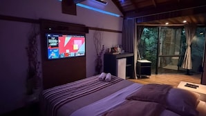 A modern bedroom with a bed, a TV, and a view of the outdoors. - DECK1920 (Cascavel)