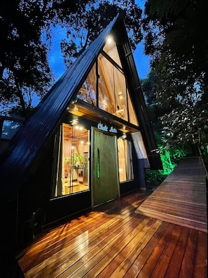 A modern, triangular-shaped building with a wooden exterior and large windows.