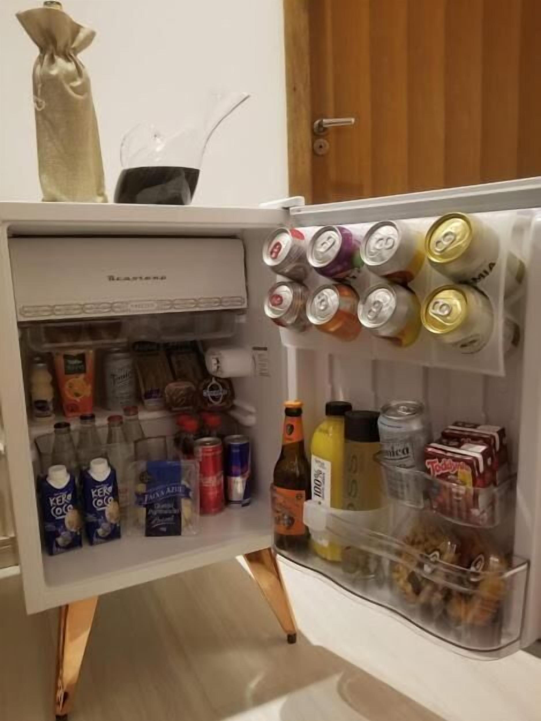 Un refrigerador lleno de diversas bebidas y alimentos.