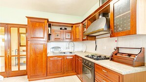 A kitchen with wooden cabinets, a stove, and a sink. - Beautiful apartment in Racisce with WiFi (Racisce)