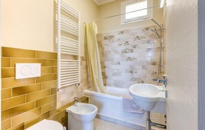 A bathroom with a bathtub, two sinks, a toilet, a shower, and a window. - 2 bedroom awesome home in Cipressa (Cipressa)