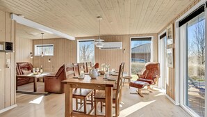 Une pièce spacieuse avec une table à manger en bois, des chaises et un canapé en cuir.