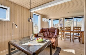 Relax in a stylish room with a leather sofa, dining area, and large window.