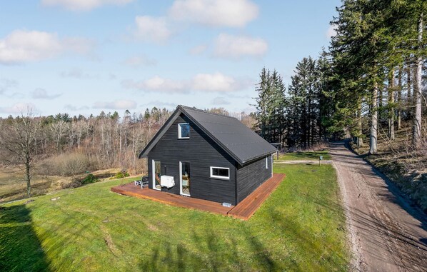 Relax on the cabin's inviting front porch amidst a serene forest setting.