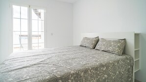 Ein Schlafzimmer mit einem Bett, einem Fenster und einer Tür.
