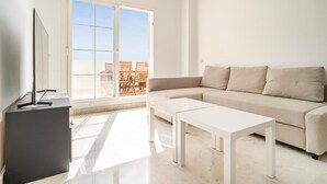 Ein modernes Wohnzimmer mit einer Couch, zwei weißen Tischen und einer Stehlampe.