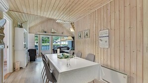 A cozy cabin interior with a dining area, wooden walls, and a calendar on the wall. - Gorgeous home in Hemmet with sauna (Hemmet)