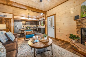 A cozy cabin interior with a dining area, kitchen, and living room. - ★Modern★ Family Friendly Cabin in Pigeon Forge - Hot Tub Game Room Fire Pit (Pigeon Forge)